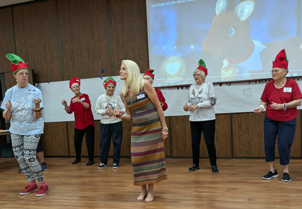 December 2024 Holiday Luncheon: Mia Lee Cooper "jiving" with Support Group Members